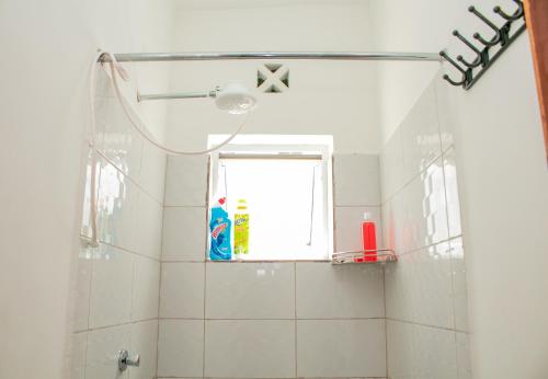 ein Bad mit einer Dusche und einem Fenster in der Unterkunft A Cozy 3 Bedroom Apartment With a Pool in Mombasa in Mombasa