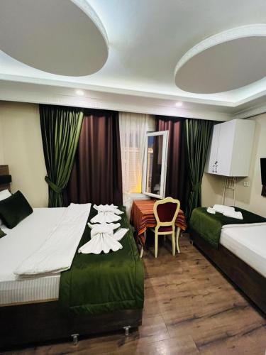 a hotel room with two beds and a chair at LALE SULTAN SÜİT APART in Istanbul