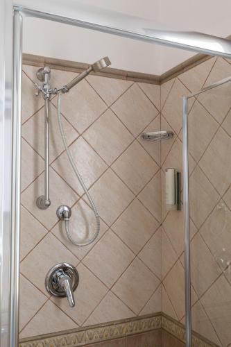 a shower with a shower head in a bathroom at Hotel Sa Suergia in Villasimius