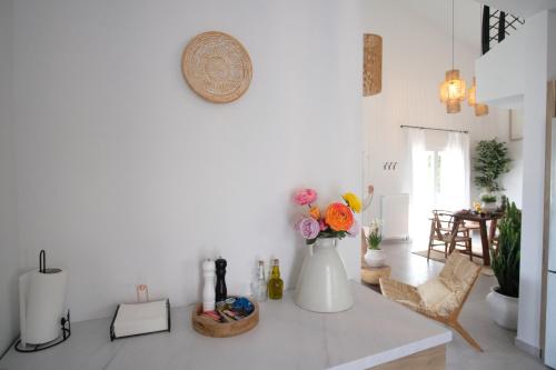 a white room with a vase of flowers on a counter at Salt & wave in Volos