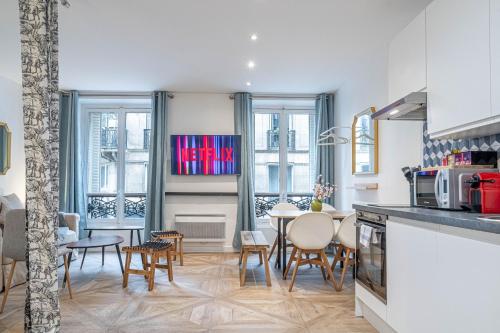 une cuisine et un salon avec une table et des chaises dans l'établissement SophieStay - Appartement tendance avec 1 chambre à Montorgueil, à Paris