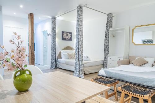 a bedroom with a bed and a vase of flowers at SophieStay - Appartement tendance avec 1 chambre à Montorgueil in Paris