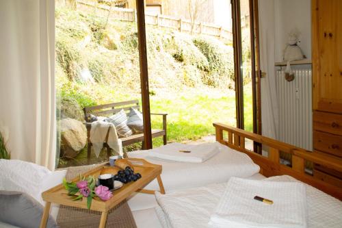 a room with two beds and a table with flowers at Ferienwohnung in Schönwald Schwarzwald in Schönwald
