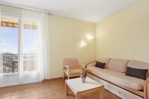 a living room with a couch and a window at Le Mas Berliat F2 N°14 in Bormes-les-Mimosas
