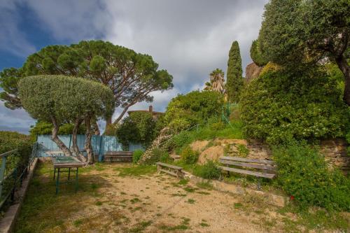 a park with benches and trees on a hill at Le Mas Berliat F2 N°14 in Bormes-les-Mimosas