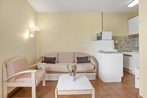 a living room with a couch and a table at Le Mas Berliat F2 N°14 in Bormes-les-Mimosas