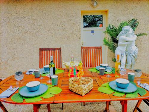 une table à manger avec une table,bestosbestosbestosbestosbestosbestosbestosbestosbestos dans l'établissement Ile des Plaisirs, Chambres d'Hôtes Naturistes avec Petit-Déjeuner Tropical Inclus, à Graulhet