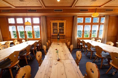 ein großer Konferenzraum mit langen Tischen und Stühlen in der Unterkunft Gasthaus Rössli in Versam