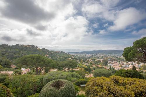 a view of a city from a hill with trees at Le Mas Berliat F2 N°14 in Bormes-les-Mimosas