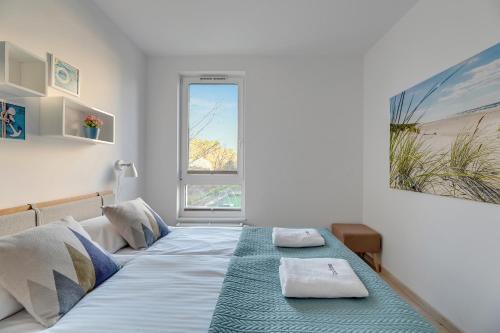 una camera da letto con un letto e due asciugamani di Dom & House - Apartments Navio Estate a Danzica