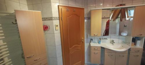La salle de bains est pourvue d'un lavabo et d'un miroir. dans l'établissement Ferienwohnung Haus am Eibach, à Erfweiler