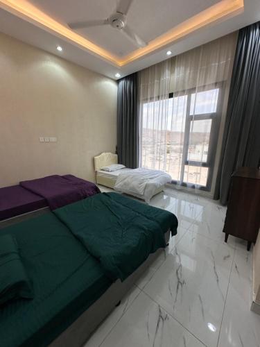 1 Schlafzimmer mit 2 Betten und einem großen Fenster in der Unterkunft Dibab house in Murrah