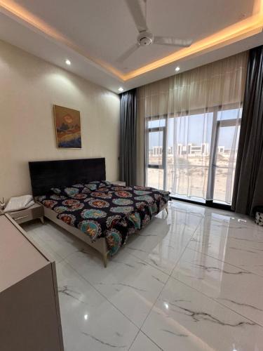 ein Schlafzimmer mit einem Bett und einem großen Fenster in der Unterkunft Dibab house in Murrah