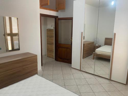 une chambre avec un miroir et une chambre avec un lit dans l'établissement Trilocale in centro, à Castelsardo