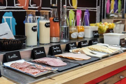a counter with meat and bread and other food items at ibis Lyon Nord in Dardilly