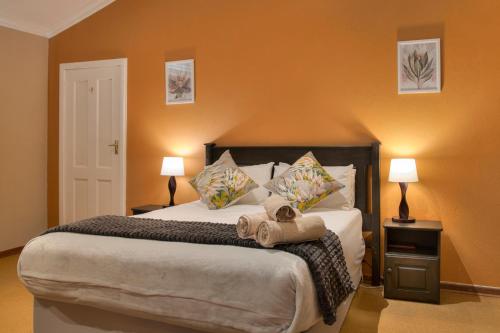 a bedroom with a large bed with two lamps at Auldstone House in Dullstroom
