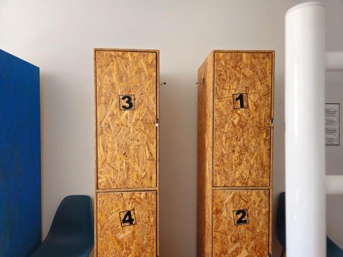 two wooden doors with numbers on the wall at Santa Maria Hostel in Funchal