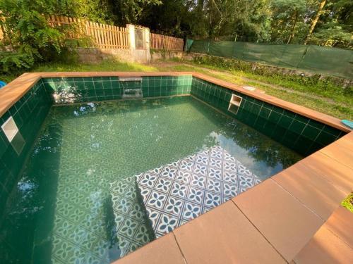 蓬特亞雷亞斯的住宿－Paraíso Gallego ®，后院的游泳池,铺有瓷砖地板