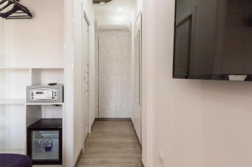 a hallway leading to a room with a flat screen tv at Hotel Sa Suergia in Villasimius