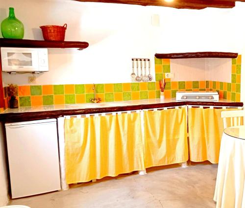 una cocina con cortinas amarillas en los mostradores en Casa Juanillo, en Miller