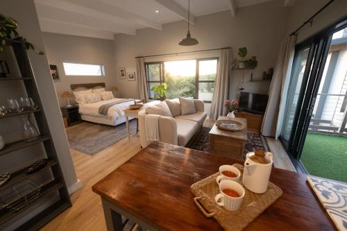 a living room with a couch and a table at Chapmans Corner Studio in Noordhoek