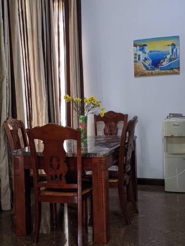 stół jadalny i krzesła ze stołem i wazonem w obiekcie Mjengoni w mieście Dar es Salaam