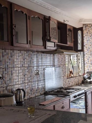 a kitchen with wooden cabinets and a stove top oven at Mjengoni in Dar es Salaam