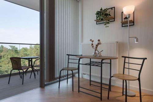 a dining room with chairs and a table and a balcony at Apartament Deluxe Sea View PINEA 621 in Pobierowo