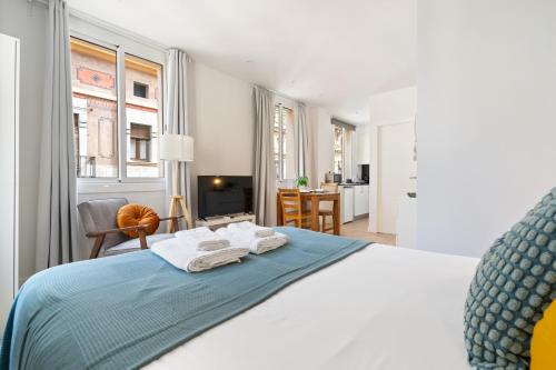 a bedroom with a bed with towels on it at Lodging Apartments Barceloneta Beach Studio 31 in Barcelona