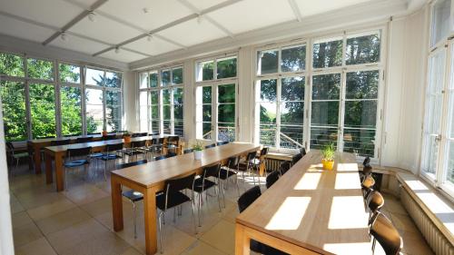 Großes Zimmer mit Tischen, Stühlen und Fenstern in der Unterkunft Kreuzlingen Youth Hostel in Kreuzlingen