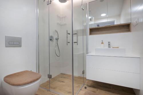 a bathroom with a shower and a toilet and a sink at Apartament Deluxe Sea View PINEA 621 in Pobierowo