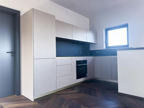 a kitchen with white cabinets and a window at LUXUS-PENTHOUSE mit Weitblick über Graz in Graz