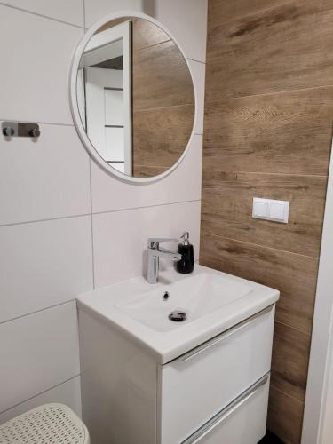 a bathroom with a white sink and a mirror at AXO-HOSTELS in Stalowa Wola