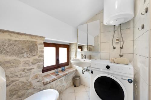 a bathroom with a washing machine and a sink at Villa Vrsar in Vrsar