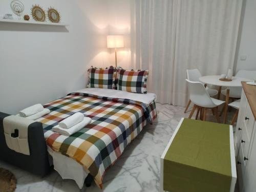 Apartamento en Lux Bormujos في بورموخوس: غرفة نوم بسرير وطاولة طعام