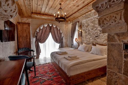 a bedroom with a large bed and a window at Chiaro Boutique Hotel in Uchisar