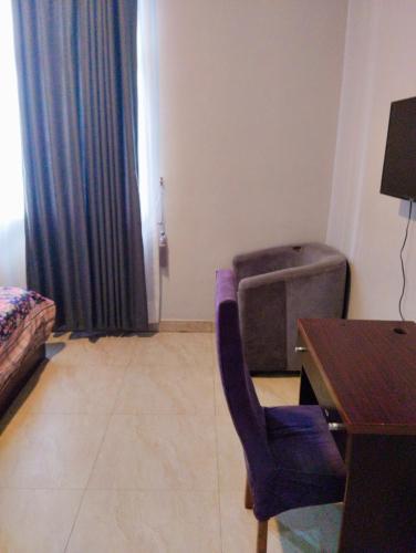 um quarto com uma secretária e uma cadeira ao lado de uma mesa em MUSAROQ HOTEL em Lagos