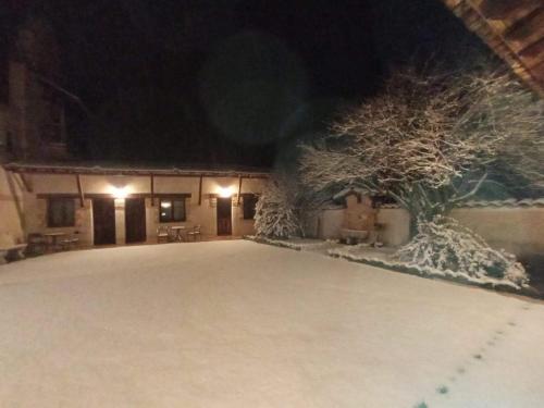 a building covered in snow at night at La Cerca Entre Hoces-10-20pax-Amplios espacios comunes in Sebúlcor
