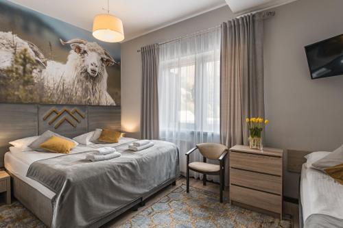 a bedroom with a bed and a painting of a goat at Hotel Smile Pieniny in Szczawnica