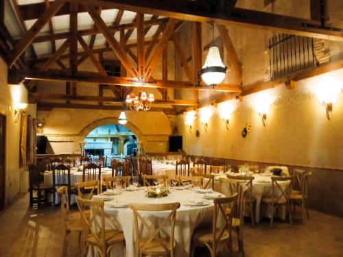 a dining room with tables and chairs with white table linen at La Cerca Entre Hoces-10-20pax-Amplios espacios comunes in Sebúlcor