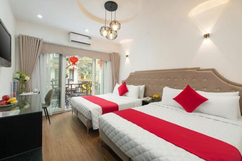 a bedroom with two beds with red and white sheets at Golden Time Hostel 3 in Hanoi