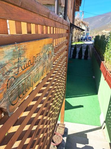 a wooden fence next to a sidewalk with a green lawn at Stara kuća in Mokra Gora