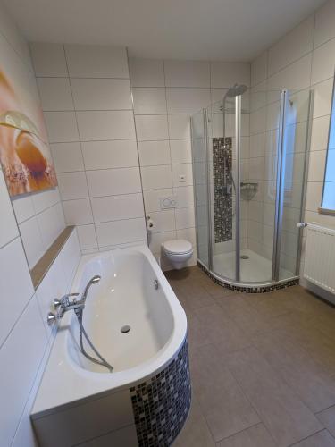 a bathroom with a tub and a shower and a toilet at Wohnen auf Zeit - workandtravel in Amberg