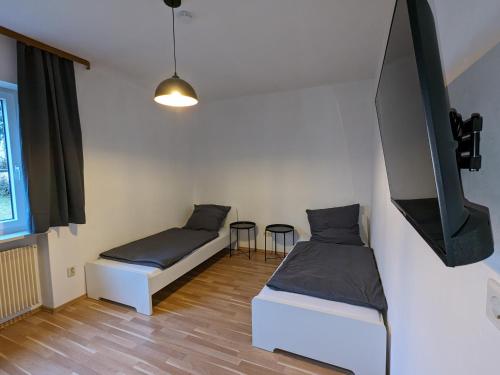 a room with two beds and a tv on the wall at Wohnen auf Zeit - workandtravel in Amberg