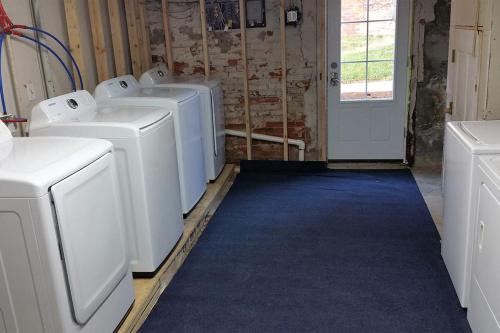 a laundry room with four washing machines and a blue carpet at The loft at Park Place - 3rd floor walk up King and Queen beds fast WIFI and free coffee in Wilmington