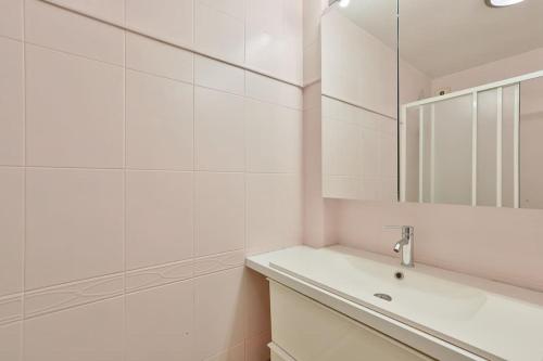 une salle de bain blanche avec un lavabo et un miroir dans l'établissement Cosy appart avec balcon Pont de Flandres - Crimée, à Paris