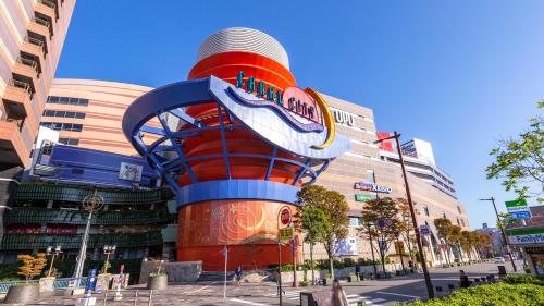 a building with a roller coaster in front of it at JR Kyushu Hotel Blossom Hakata Central in Fukuoka
