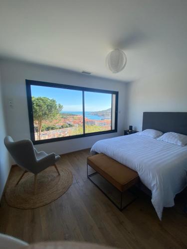 - une chambre avec un lit, une chaise et une grande fenêtre dans l'établissement Magnifique appartement vue mer 3STRAT51, à Port-Vendres