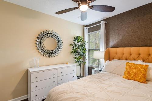 - une chambre avec un lit, un ventilateur de plafond et un miroir dans l'établissement 3BR Decatur Townhouse: Near Downtown, Pet-Friendly, à Decatur