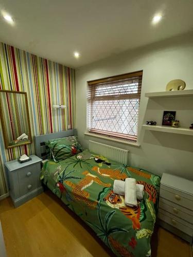 ein kleines Schlafzimmer mit einem Bett und einem Fenster in der Unterkunft Spacious 4-Bed Haven - Free Parking & Wi-Fi in Whitefield
